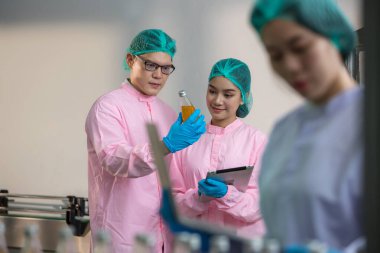 Worker Checking quality or checking stock of glass bottle in beverage factory. Worker QC working in a drink water factory 