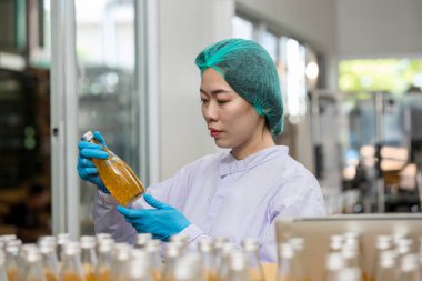 Worker Checking quality or checking stock of glass bottle in beverage factory. Worker QC working in a drink water factory 