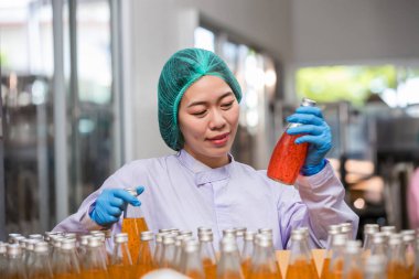Worker Checking quality or checking stock of glass bottle in beverage factory. Worker QC working in a drink water factory 