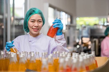 Worker Checking quality or checking stock of glass bottle in beverage factory. Worker QC working in a drink water factory 