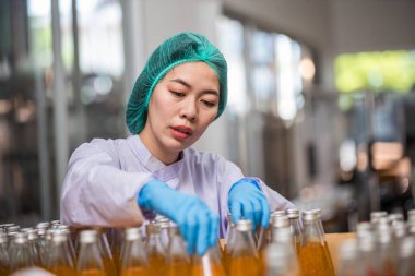 Worker Checking quality or checking stock of glass bottle in beverage factory. Worker QC working in a drink water factory 