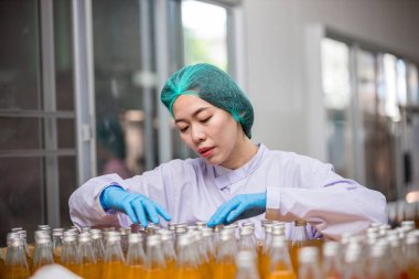 Worker Checking quality or checking stock of glass bottle in beverage factory. Worker QC working in a drink water factory 
