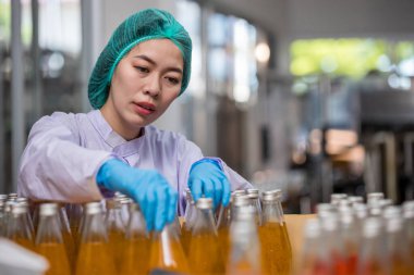 Worker Checking quality or checking stock of glass bottle in beverage factory. Worker QC working in a drink water factory 
