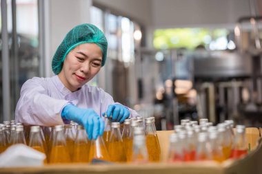 Worker Checking quality or checking stock of glass bottle in beverage factory. Worker QC working in a drink water factory 
