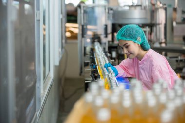 Worker Checking quality or checking stock of glass bottle in beverage factory. Worker QC working in a drink water factory 