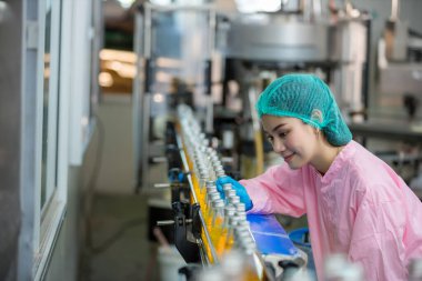 Worker Checking quality or checking stock of glass bottle in beverage factory. Worker QC working in a drink water factory 