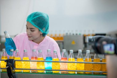 Worker Checking quality or checking stock of glass bottle in beverage factory. Worker QC working in a drink water factory 