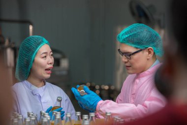 Worker Checking quality or checking stock of glass bottle in beverage factory. Worker QC working in a drink water factory 