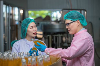 Worker Checking quality or checking stock of glass bottle in beverage factory. Worker QC working in a drink water factory 