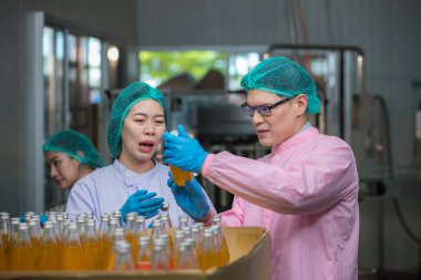 Worker Checking quality or checking stock of glass bottle in beverage factory. Worker QC working in a drink water factory 