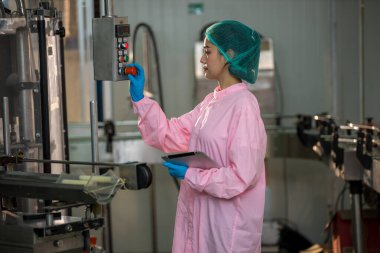 Worker Checking quality or checking stock of glass bottle in beverage factory. Worker QC working in a drink water factory 