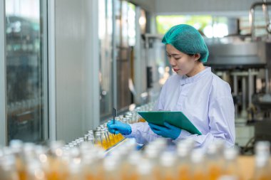 Worker Checking quality or checking stock of glass bottle in beverage factory. Worker QC working in a drink water factory 