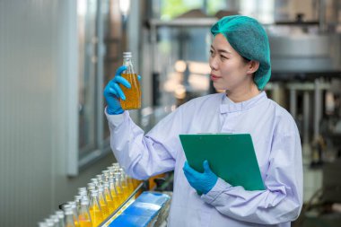 Worker Checking quality or checking stock of glass bottle in beverage factory. Worker QC working in a drink water factory 