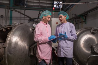 Worker Checking quality or checking stock of glass bottle in beverage factory. Worker QC working in a drink water factory 