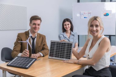 İş adamı güneş pili paneli teknolojisinde buluşuyor. İş adamları güneş enerjisi çevre kavramını tartışıyor. Yeşil alternatif enerji kavramı