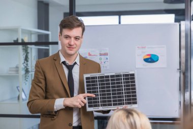 İş adamı güneş pili paneli teknolojisinde buluşuyor. İş adamları güneş enerjisi çevre kavramını tartışıyor. Yeşil alternatif enerji kavramı