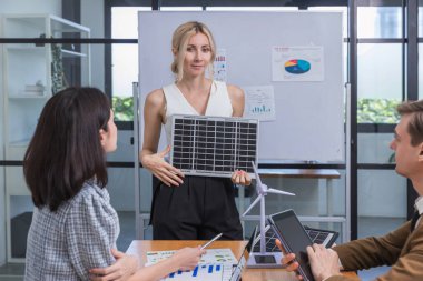 İş adamı güneş pili paneli teknolojisinde buluşuyor. İş adamları güneş enerjisi çevre kavramını tartışıyor. Yeşil alternatif enerji kavramı
