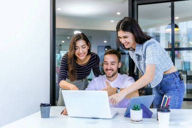Modern Ofis 'te yeni bir başlangıç projesi üzerinde çalışan iş adamları. Muhtelif iş adamlarından oluşan bir grup bir ofisteki toplantı masasının etrafında birlikte çalışıyor.