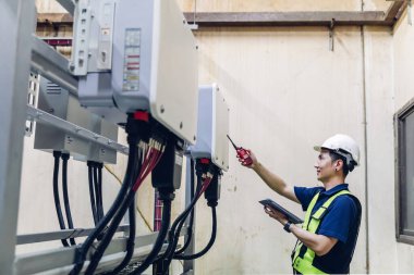 Kontrol odasında çalışan elektrik mühendisi. Elektrik mühendisi kontrol odasındaki güç dağıtım dolabını kontrol ediyor.