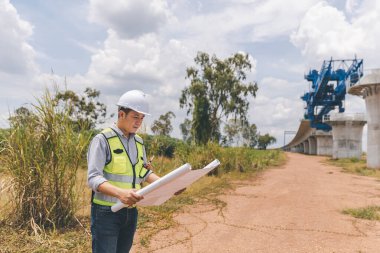 İnşaat alanında teodolit alet teçhizatıyla ölçüm yapan mühendis. Araştırmacılar veya gezgin görünümlü inşaat alanları veya güvenliği kontrol edin