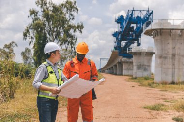 İnşaat alanında teodolit alet teçhizatıyla ölçüm yapan mühendis. Araştırmacılar veya gezgin görünümlü inşaat alanları veya güvenliği kontrol edin