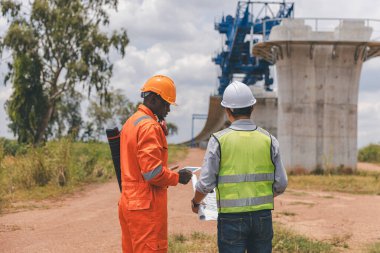 İnşaat alanında teodolit alet teçhizatıyla ölçüm yapan mühendis. Araştırmacılar veya gezgin görünümlü inşaat alanları veya güvenliği kontrol edin