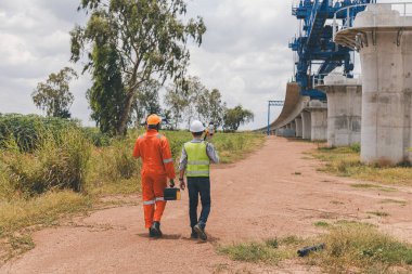 İnşaat alanında teodolit alet teçhizatıyla ölçüm yapan mühendis. Araştırmacılar veya gezgin görünümlü inşaat alanları veya güvenliği kontrol edin