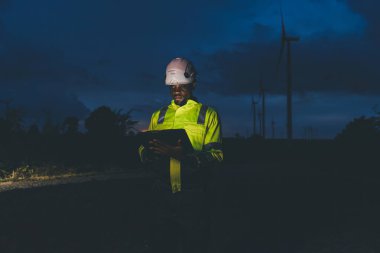 Petrokimya Mühendisi Ekibi geceleyin petrol ve gaz rafinerisi fabrikasının planlarıyla çalışıyor.