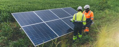 Tarım arazisindeki güneş panellerini kontrol eden mühendis. Olay yerinde güneş panellerini inceleyen mühendis. Teknisyenler tarım alanındaki güneş enerjili voltaik panelleri tamir ediyorlar. temiz enerji