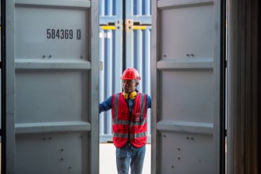 Ustabaşı ya da işçi konteyner kargo alanında çalışıyor. Konteynırdaki malları kontrol ediyor. Ustabaşı ya da işçi konteynırları kontrol ediyor. Lojistik ve nakliye