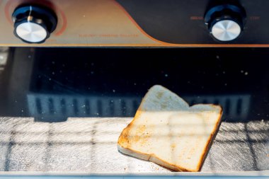 Elektrikli konveyör tost fırınının ekmeği oteldeki ısıtma sistemi ile çalıştırılıyor. Tost makinesinde bir somun ekmek..