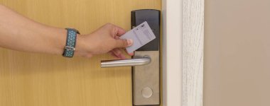 Oteldeki akıllı kart kapısı kilit sistemi. Ahşap kapıdaki otel elektronik kilidi. Elektronik kartı olan giriş kapısı. Otelin korunması için dijital kapı kilitleme sistemleri