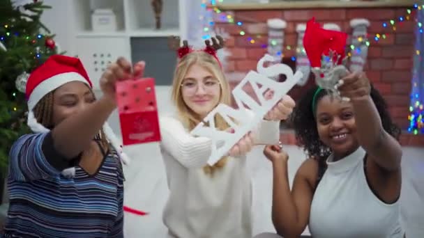 Κορίτσια Κρατούν Χριστουγεννιάτικα Σύμβολα Στο Χέρι Χριστουγεννιάτικη Επιγραφή Χαμογελώντας Αφρικανικές — Αρχείο Βίντεο