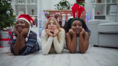 Afrika ve Avrupa 'dan üç arkadaş. Uluslararası Noel dünyası. Noel sembolleri takmış kızlar.