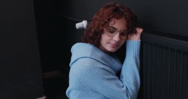 Dziewczyna Okularach Kręconymi Włosami Przytula Gorący Grzejnik Ogrzewanie Domu Zimne — Wideo stockowe