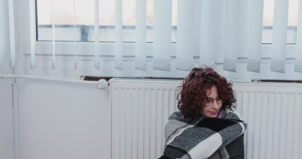 女人喜欢依偎在炽热的散热器上 冬季迫使中央暖气被打开 — 图库视频影像