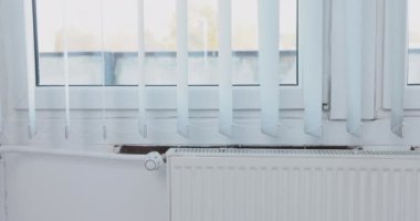 Paneldeki ısıtıcıdan gelen sıcak hava nedeniyle dikey kapakçıkların nazik hareketi. Merkezi ısıtma kış dönemi için başladı.