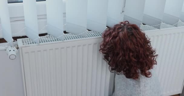 Дівчина Чіпляється Ледь Теплий Радіатор Під Час Несправного Опалення Одягнена — стокове відео