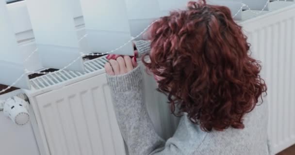 Eine Warm Gekleidete Frau Sitzt Heizkörper Und Umarmt Ihn Zum — Stockvideo