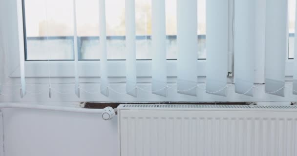 用垂直百叶窗装饰窗户 在散热器热空气的影响下 垂直百叶窗轻轻摇曳 — 图库视频影像