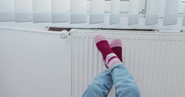 在热散热器上暖你的脚 在寒冷的天气里 你的脚需要保暖 冬天的季节迫使你打开中央暖气 — 图库视频影像