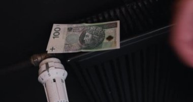 Isıtma enerji şarjlarını arttır. Banknotlar radyatörün üzerine bırakıldı. Isıtma harcamalarına bağlı olarak ev bütçesi.