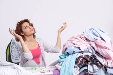 Yalvarma jesti olarak elleri göğe kaldırıldı. Bir kız erkek gömleklerini ütülerken yardım için dua eder..