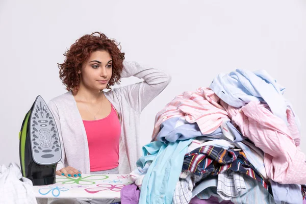 A woman wonders how to get down to ironing such a large amount of clothing. The surprised look on the girls face before starting her homework.