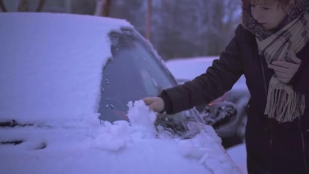 早上在停车场的第一件事就是一个女人擦着车窗的雪现在是雪下得很大的冬季 — 图库视频影像