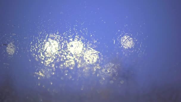 湿ったフロントガラスを通して見られる白い光 雨と曇りの天気 不安定な焦点 前景がぼやけている ボケの写真効果 — ストック動画