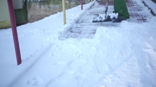 敷石から積雪を除去するエリアホスト 作業服の労働者は 凍結雪の都市の不動産の領域をクリアします — ストック動画