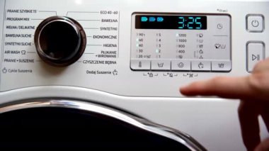 Panel with buttons to control the automatic washing machine. Modern home automatic washing machine. He turns on the buttons with his finger. Home household appliances.