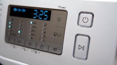Controlled switching on and off the automatic washing machine with the push of a button. Front control panel with display home washing machine. Home appliances.