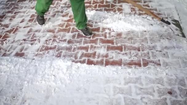 敷地のホストは 着実な動きで舗装石から雪をクリアします 豪雪時の冬季勤務 — ストック動画